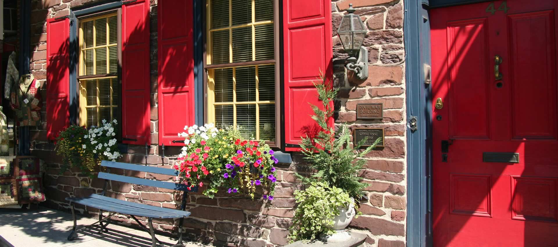 The front entry of the Brafferton Inn with flowers and bench