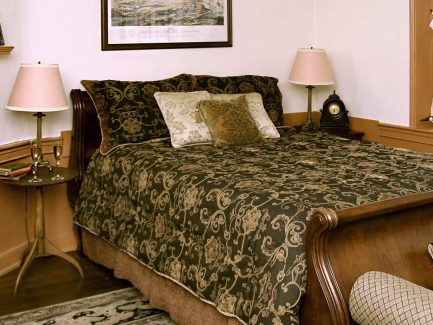 The Battle Room bed and fireplace mantle with the musket ball hole