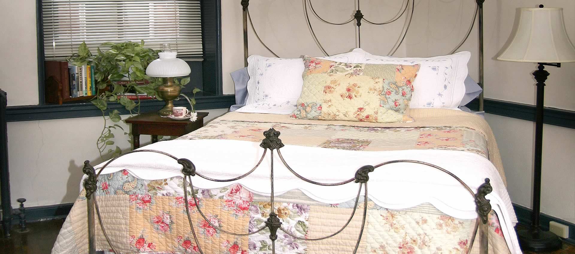 the bed of the Michael Hoke room with table and lamp