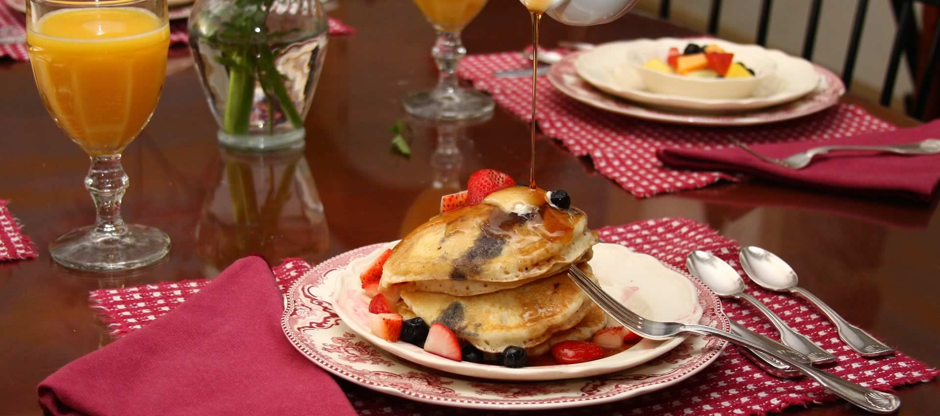 Bafferton Breakfast dish, syrup being poured over strawberry pancakes