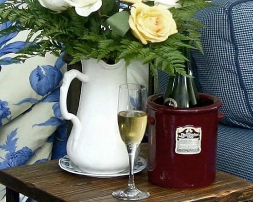 Glass of wine with a vase of yellow roses
